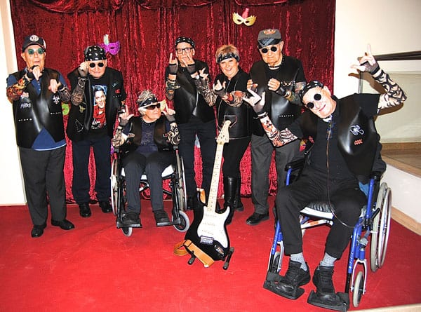 Un grupo de residentes y familiares posan para la foto disfrazados de grupo de metal en el concurso de disfraces de Allegra