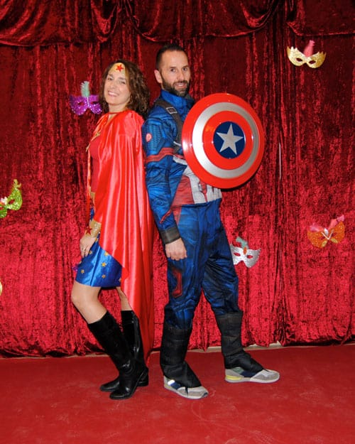 Una pareja, familiares de residentes, posan sonrientes disfrazados de supermujer y super hombre