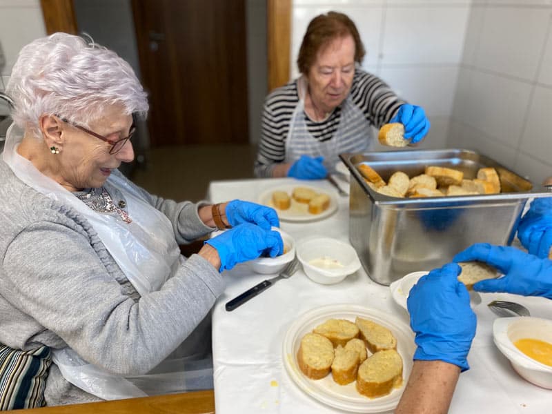 Dos residentes preparan el pan para hacer torrijas