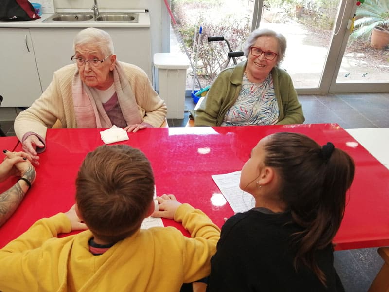 Niños realizan preguntas a los residentes en el taller de radio celebrado en Benviure