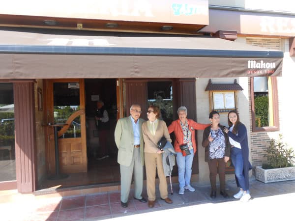 Residentes posan sonrientes en el exterior del restaurante de comida asturiana
