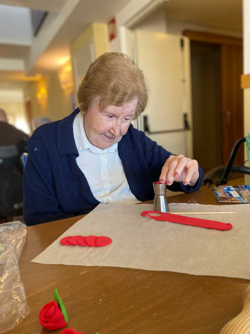 Residente realiza una manualidad de broche de una rosa el Día de Sant Jordi