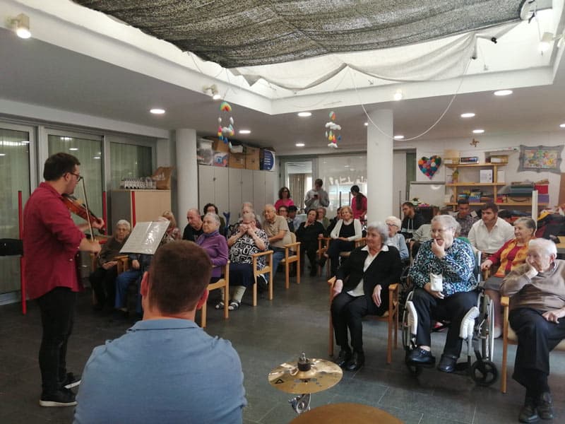 Residentes disfrutan de la actuación musical del grupo de alumnos de Camps Blancs