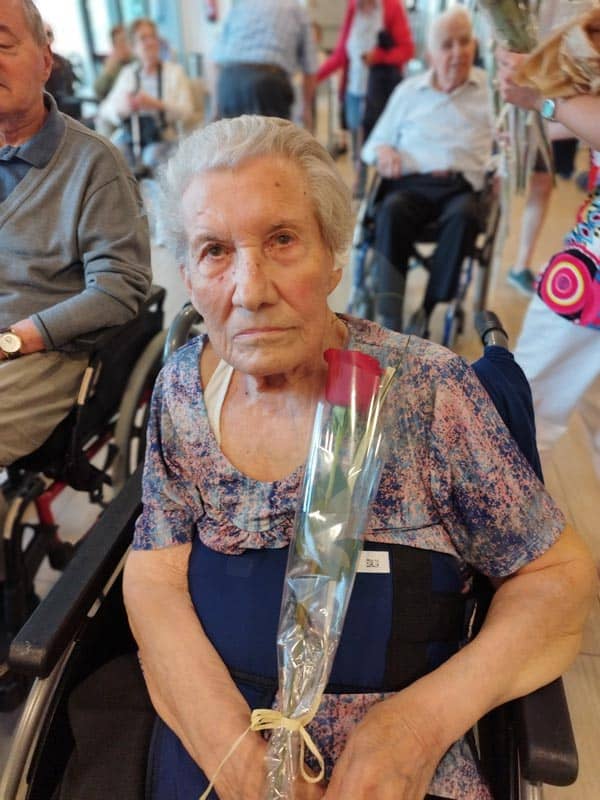 Residente cumpleañera posa con una rosa