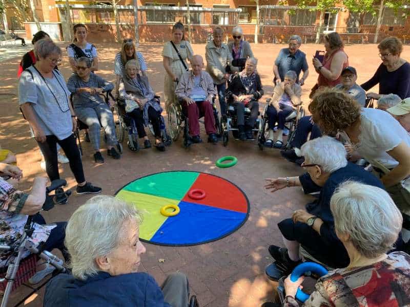 Los residentes de Sabadell-Allegra juegan con familiares y cuidadores a un juego de lanzar aros