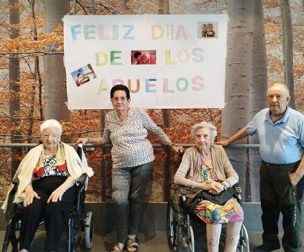 Residentes posan junto al cartel de "Feliz día de los abuelos"