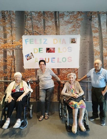 Residentes posan junto al cartel de "Feliz día de los abuelos"