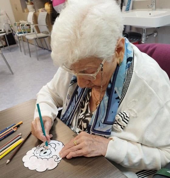 Una residente pinta un dibujo durante la celebración del "Día de los Abuelos"