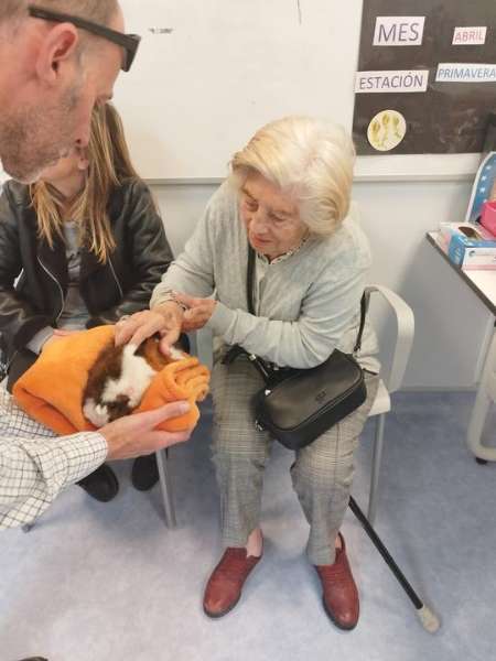 Residente feliz toca a un cachorro de perro de terapia