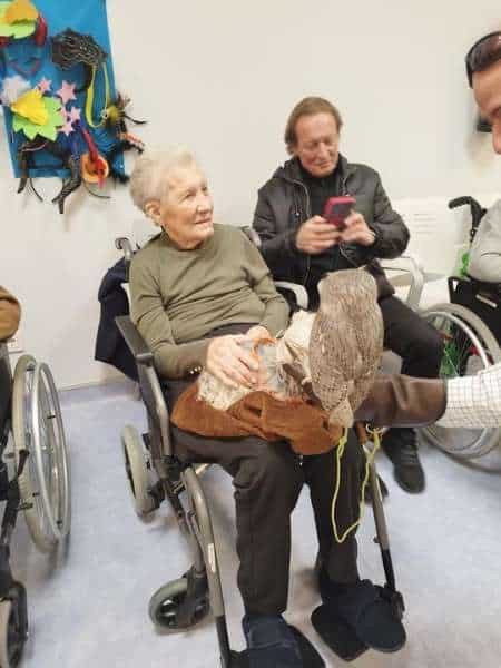 Residente presta atención a la persona responsable de los animales de terapia