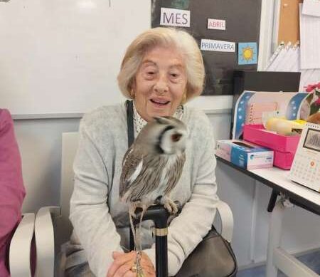 Residente sonríe sosteniendo a un buho de terapia