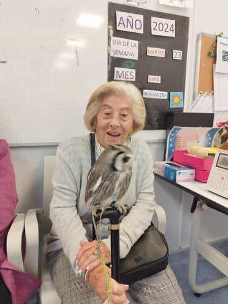 Residente sonríe sosteniendo a un buho de terapia