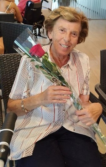 Residente sonríe a la cámara rosa en mano