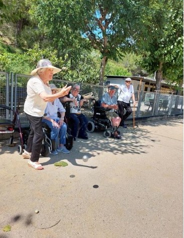 Una residente lanza la pelota de la petanca