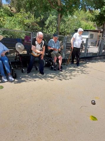 Residentes se mantienen a la sombra mientras juegan a la petanca
