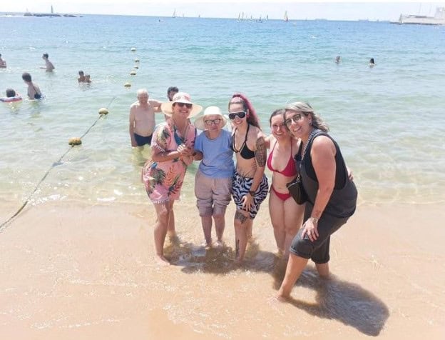Residentes posan sonrientes en al orilla de la playa