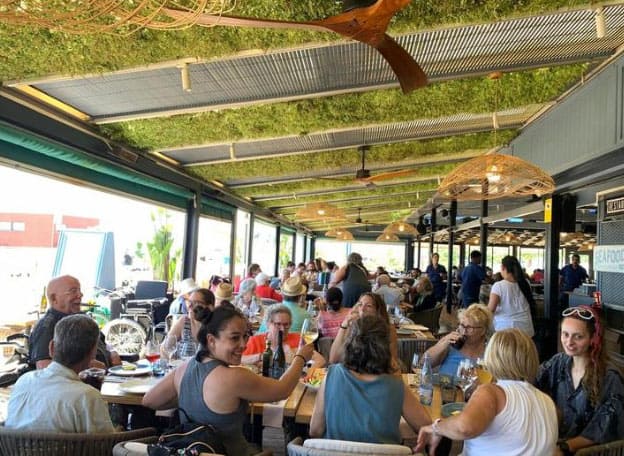 Residentes y trabajadores comparten una comida con vistas al mar
