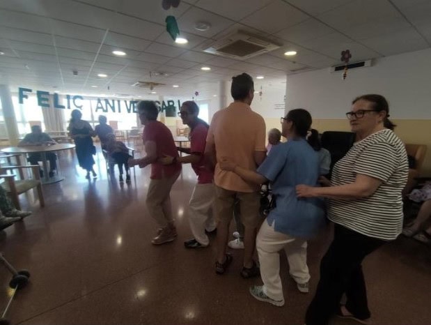Residentes y trabajadores bailan la conga para celebrar los cumpleaños del mes