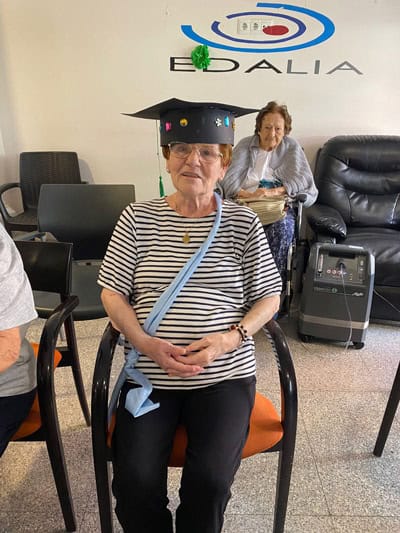 Residente posa feliz en el salón con su gorro de graduación