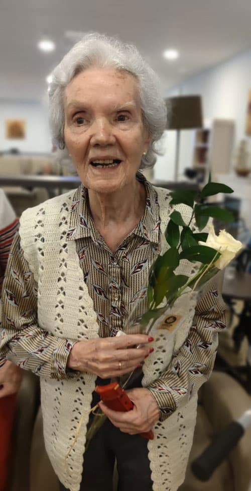 Residente posa feliz con una rosa por su cumpleaños