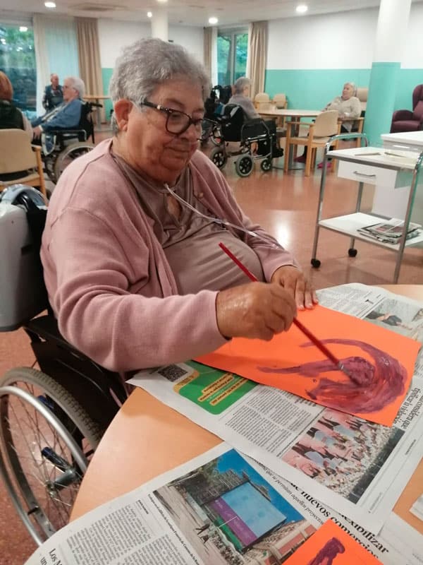 Residente pintando un dibujo que se utilizará como decoración de la residencia