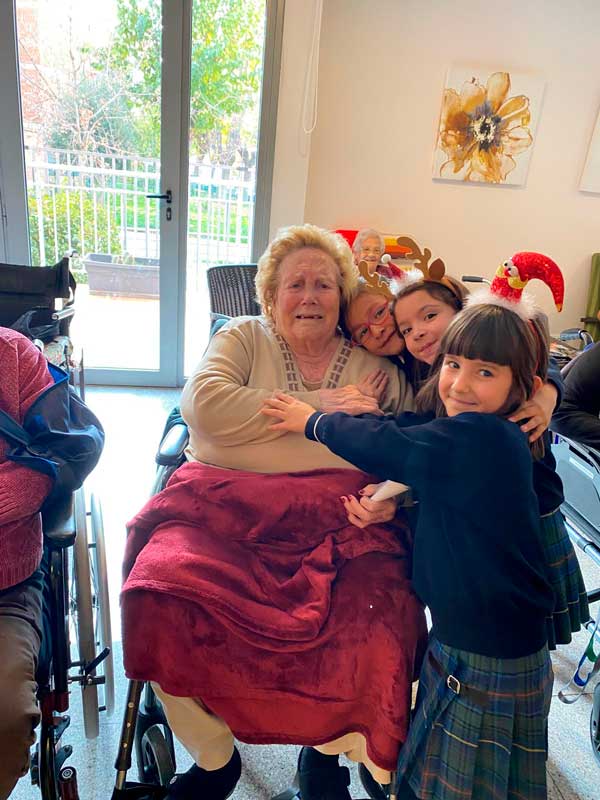 Una residente sonríe para la foto junto a varios niños y niñas