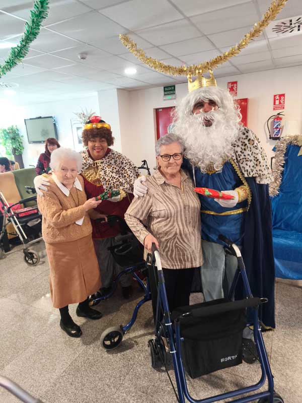 Una residente con carrito y una amigo posan junto a los Reyes