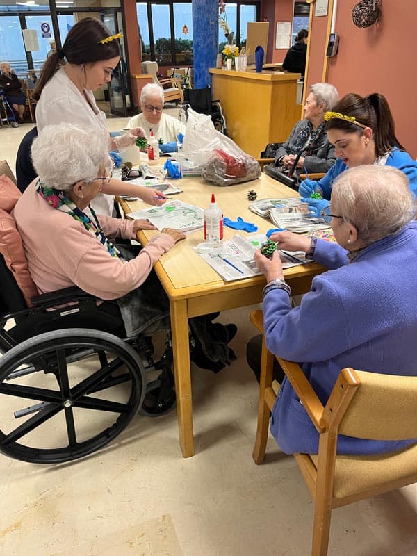 Residentes realizan manualidades junto a varias auxiliares
