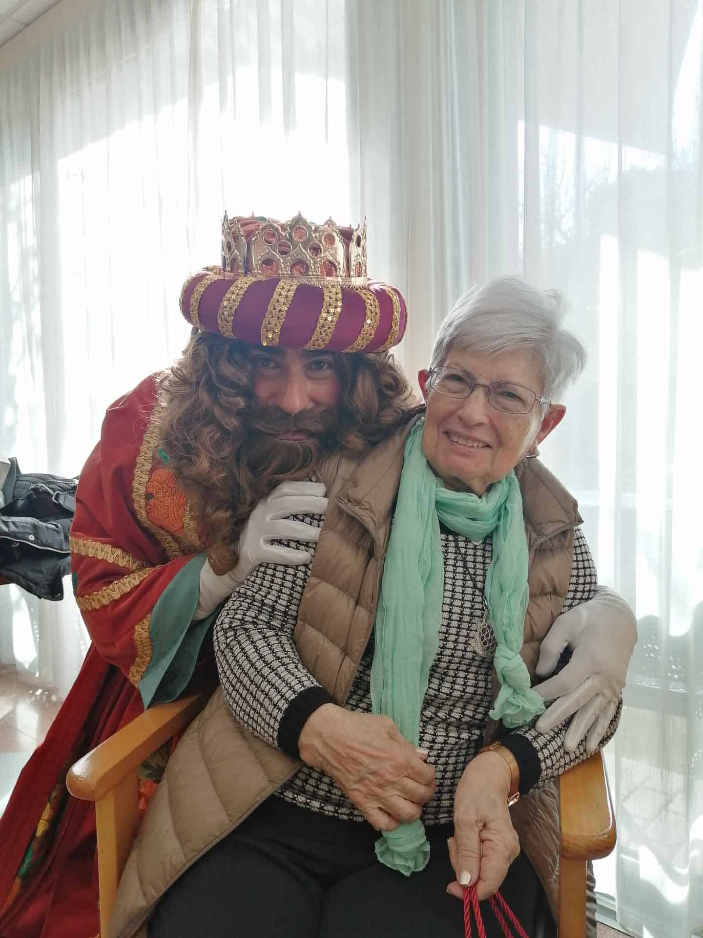 Una residente de Benviure posa con el rei Melchor