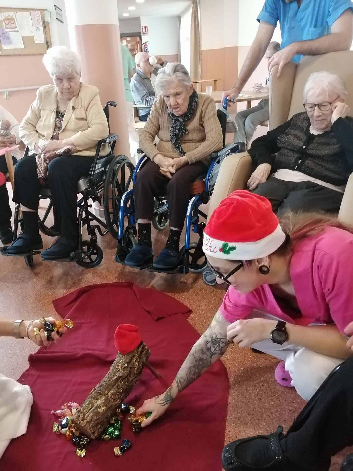 Una auxiliar acaricia al tió para que cague regalos