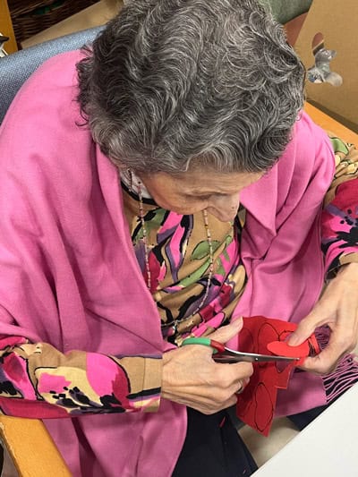 Una residente recorta un corazón rojo