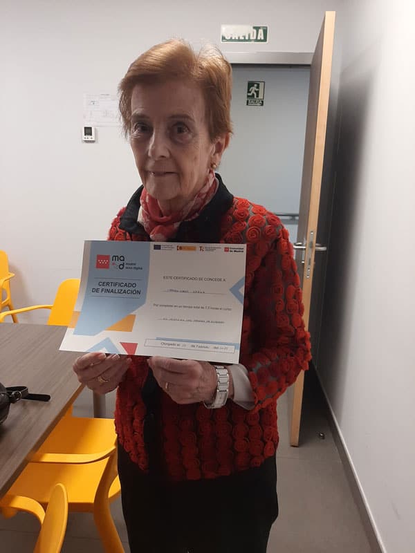 Residente posa con su certificado de finalización del curso