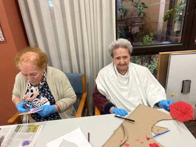Residentes ríen mientras elaboran manualidades
