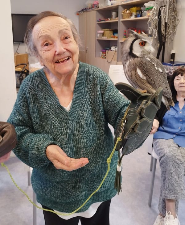 Residente posa sonriente junto al buho