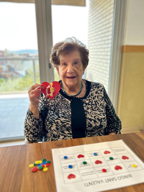 Una residente muestra las fichas del bingo que ya ha tachado