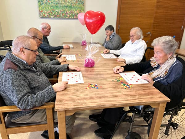 Una mesa con varios residentes jugando al bingo musical