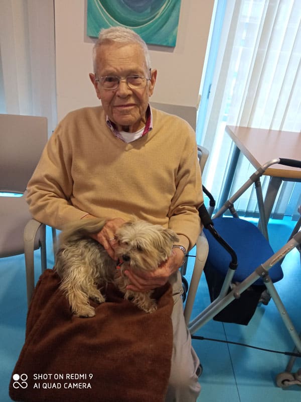 Un residente de Torrejón-Edalia acaricia a un perrito