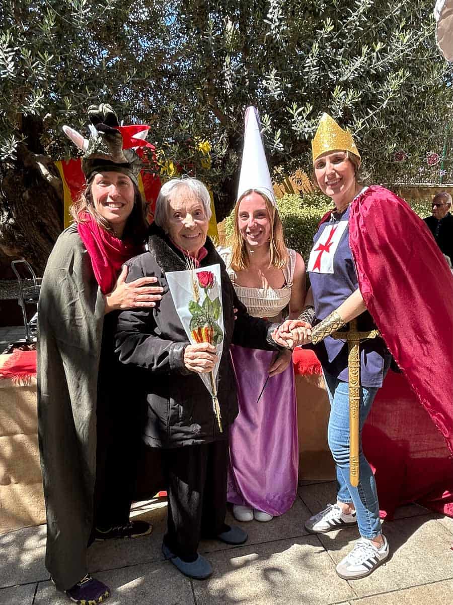 Otra residente con su rosa posa junto a empleados