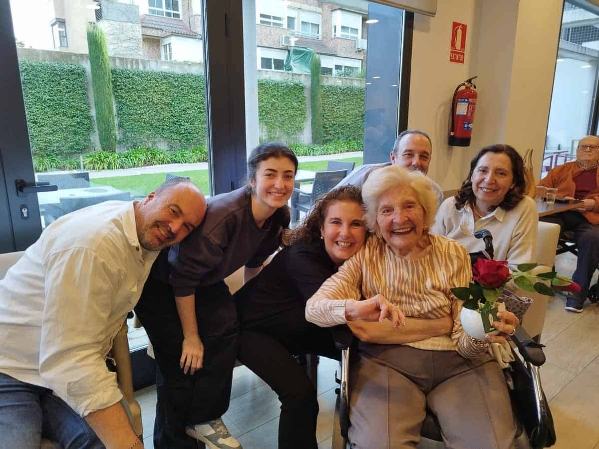 Un grupo de familiares junto a una residente que cumple años