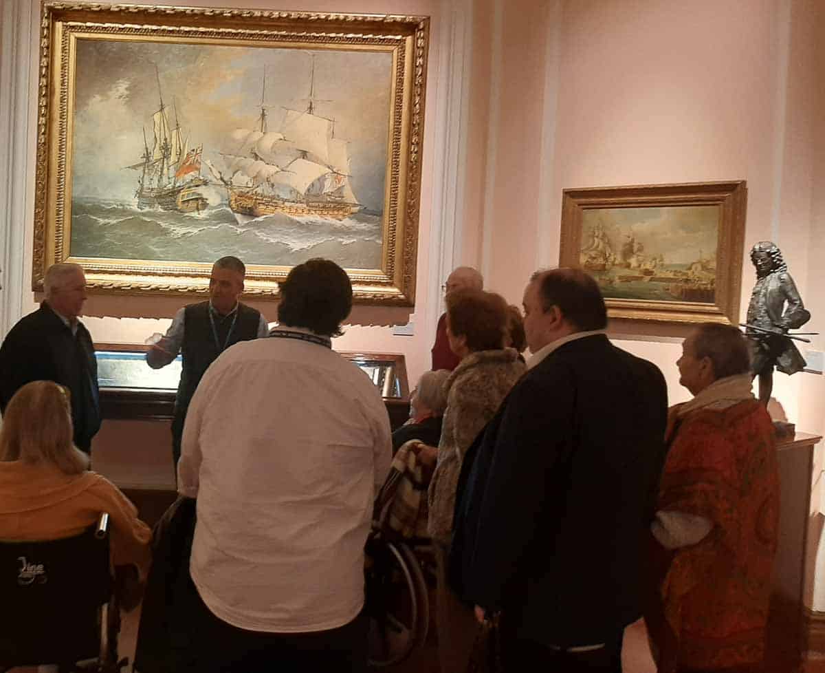 Un ponente explica a los residentes una obra del museo naval