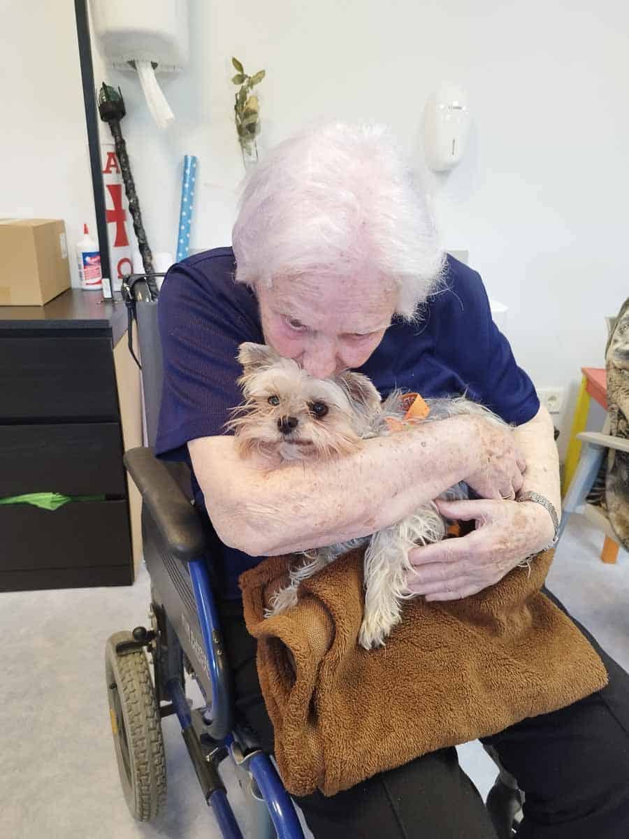 Una residente abraza a un perro de terapia