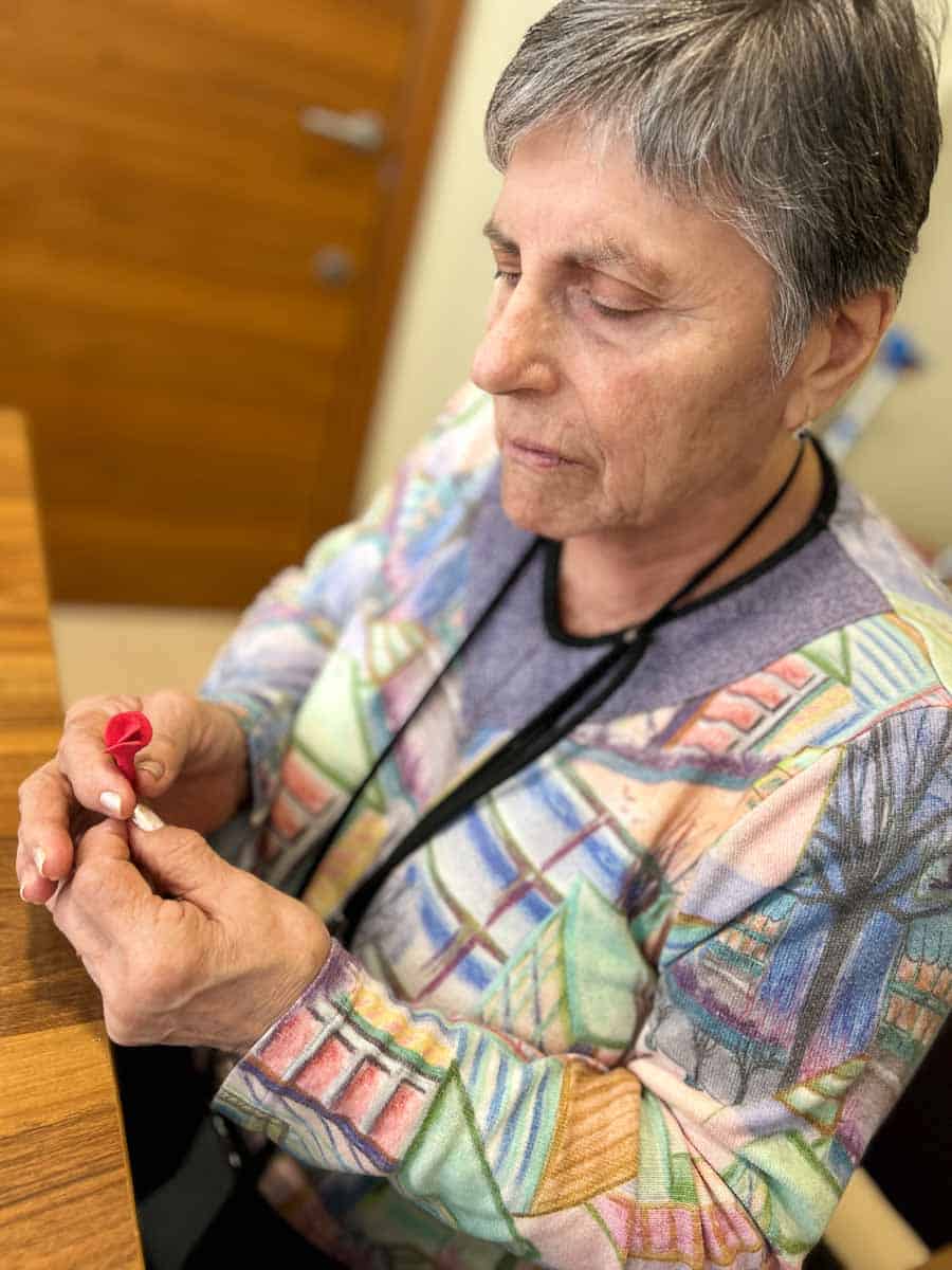 Una residente elabora una rosa como manualidad