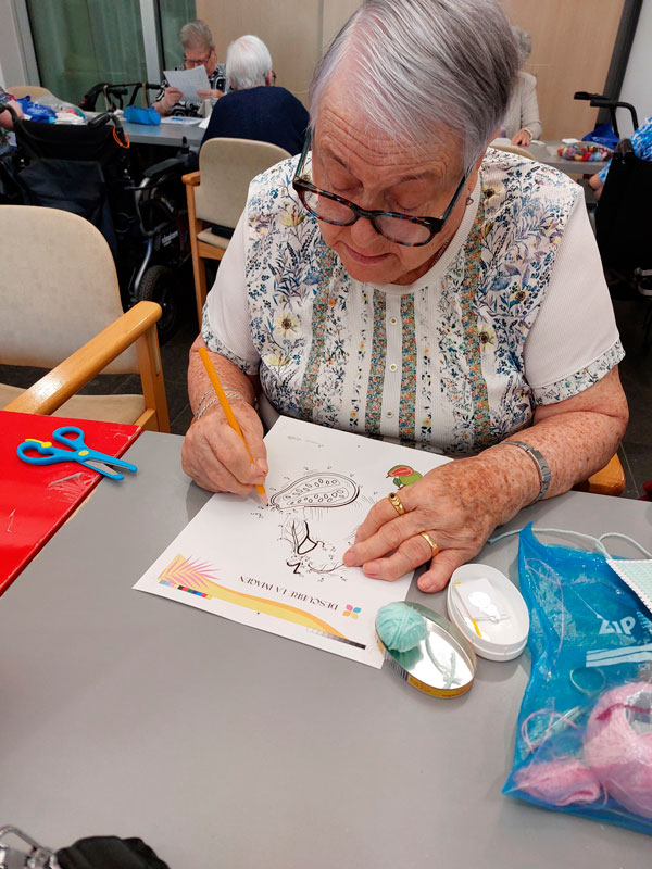 Una residente pinta un dibujo sobre el Día de los abuelos