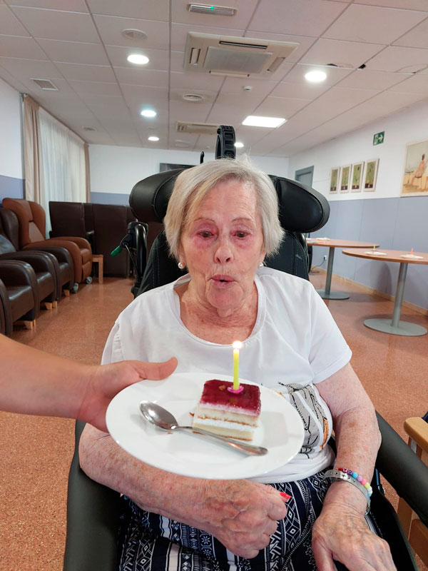 Una cumpleañera feliz junto a su tarta