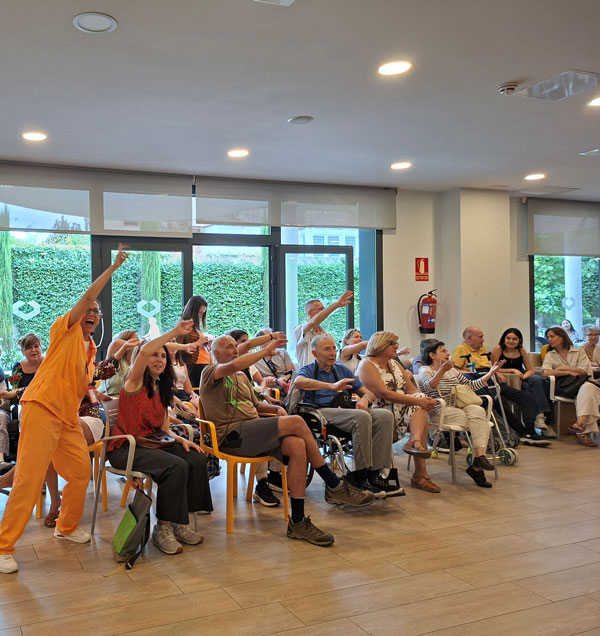 El comedor repleto de residentes baila durante la celebración de cumpleaños