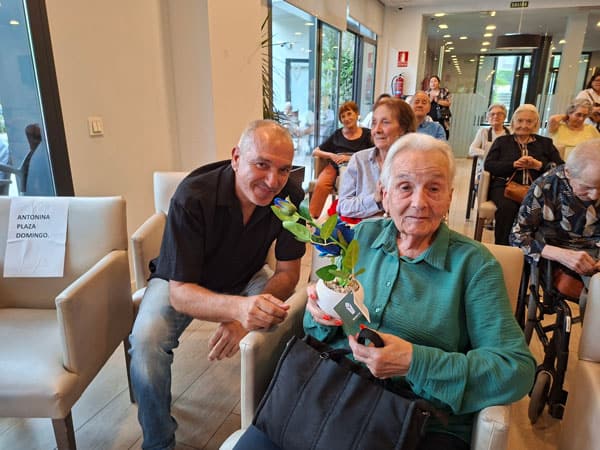 Otra residente junto a sus familiares sonríe por su cumpleaños