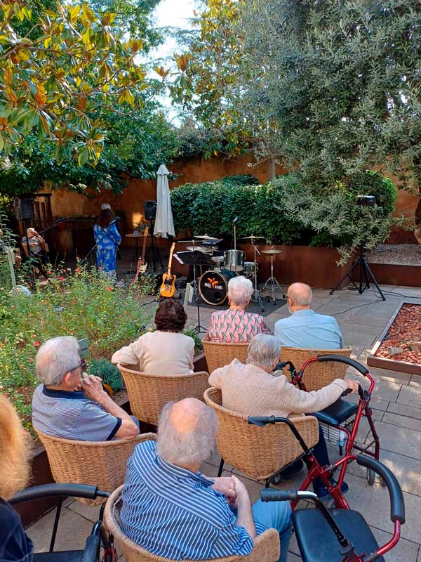 Imagen de los residentes en el jardín esperando el inicio del concierto de la MGS Band