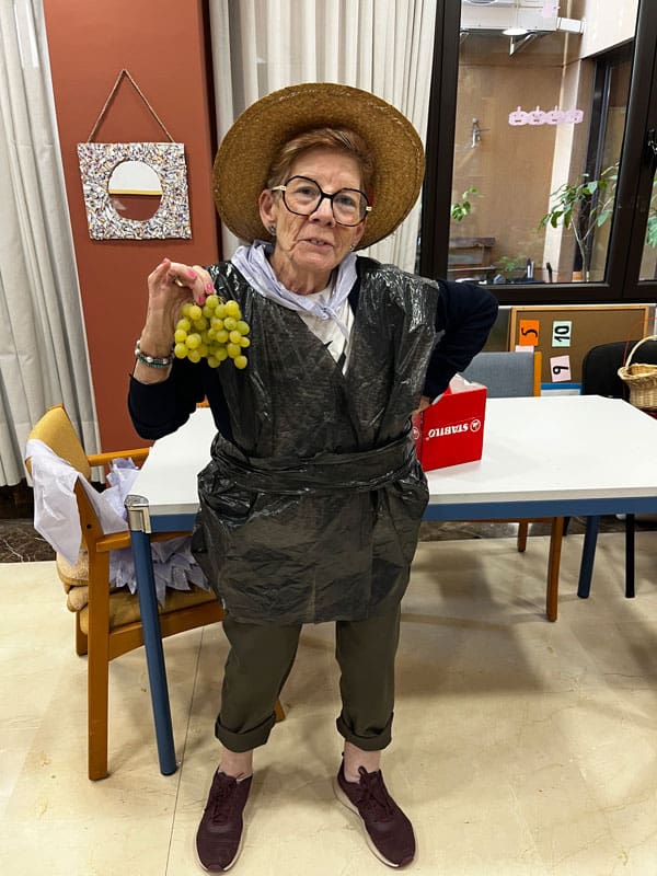 Una residente posa con un racimo de uvas