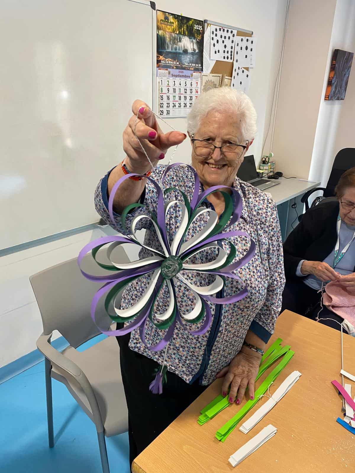Una residente muestra feliz su manualidad