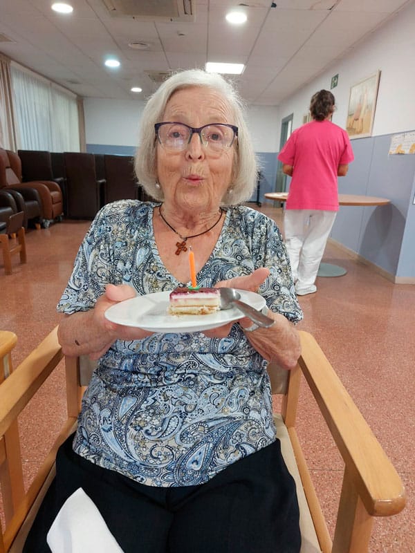 Una cumpleañera sopla las velas de su pastel